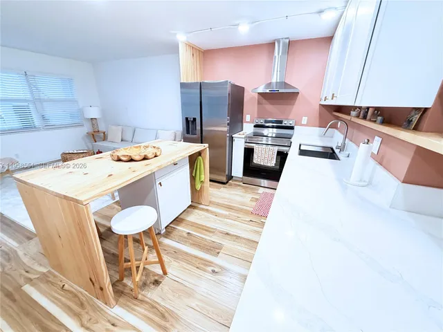 a large kitchen with stainless steel appliances a stove a sink dishwasher and a refrigerator