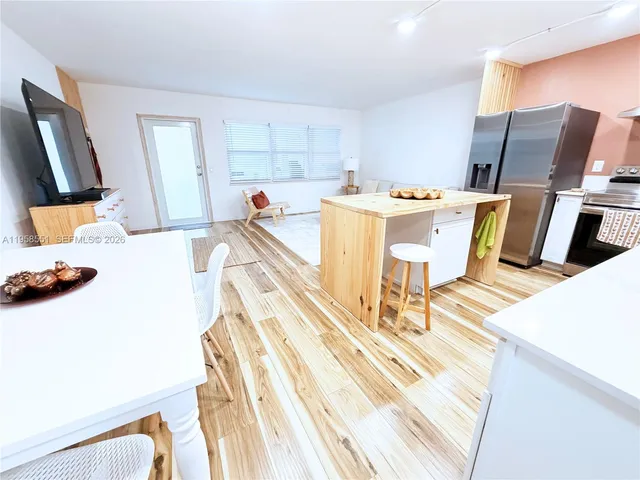 a living room with a couch wooden floor and a dining table