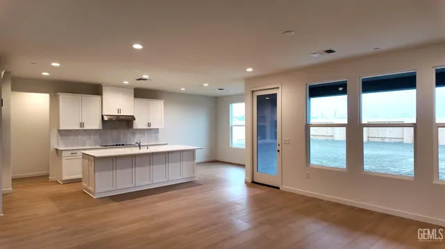 a large kitchen with a large window and stainless steel appliances