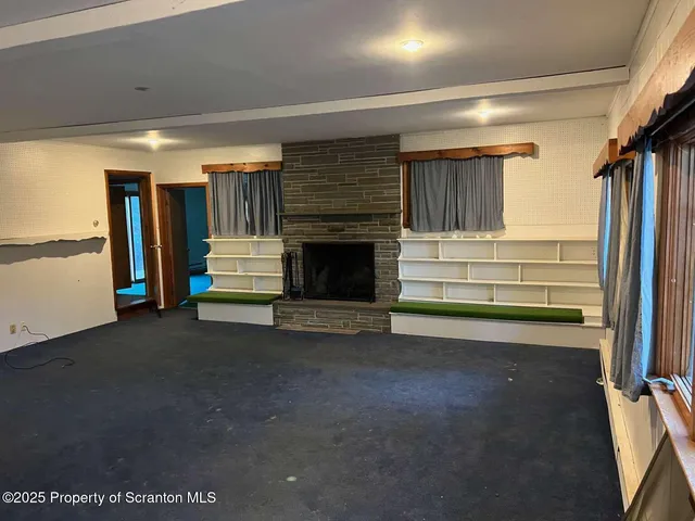 a view of empty room with wooden floor and fireplace