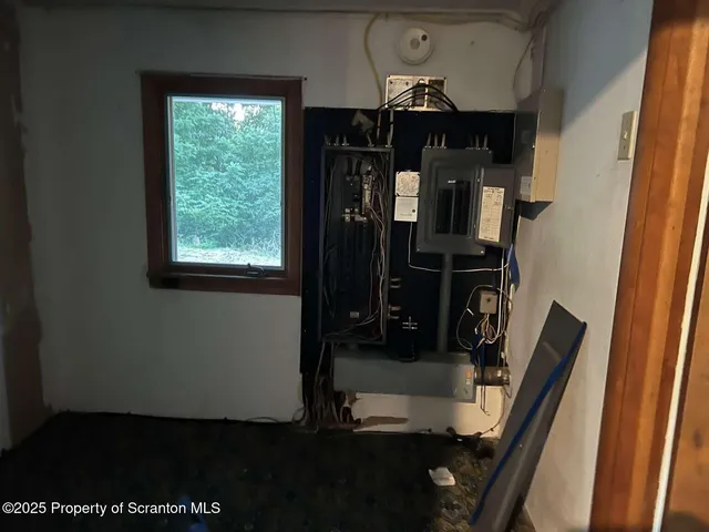 a view of an empty room with window and stairs