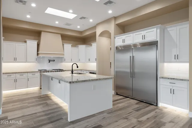 a kitchen with stainless steel appliances granite countertop a refrigerator and a sink