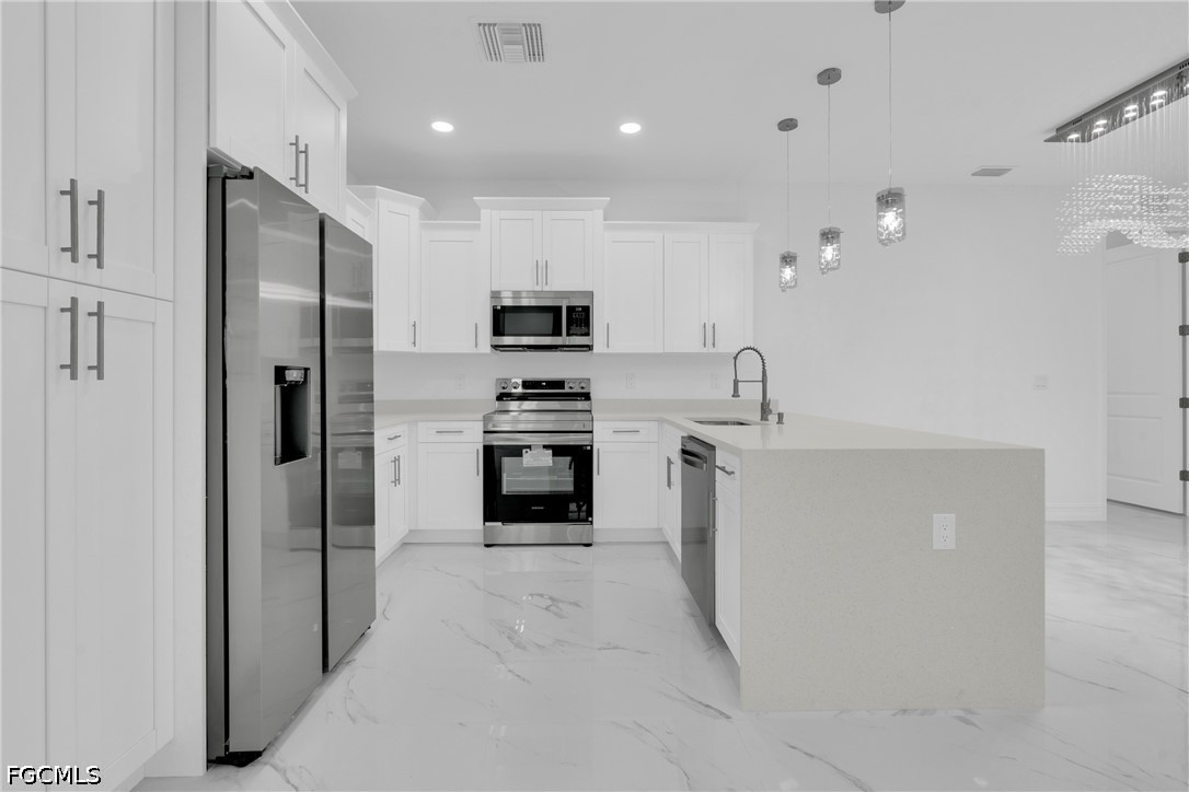 2115 Polar Avenue Alva, FL 33920 - Photo 13 of 26 a kitchen with white cabinets and stainless steel appliances