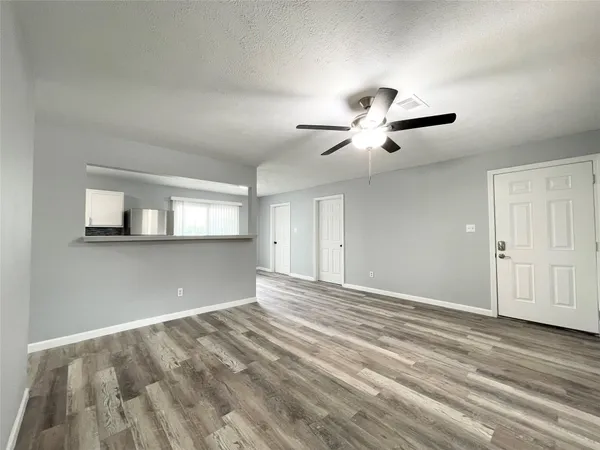 a view of empty room with wooden floor