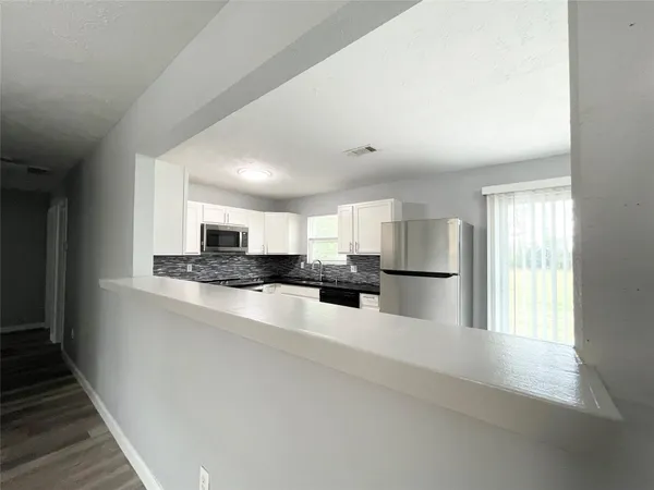 a kitchen with granite countertop a sink stainless steel appliances and cabinets