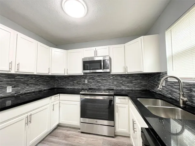 a stove top oven sitting inside of a kitchen