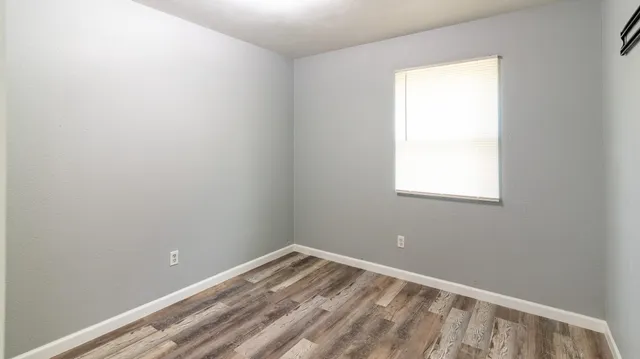 a view of a small space with wooden floor and a window
