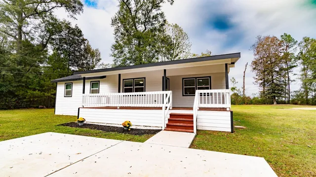 a view of a swimming pool with a big yard and large trees