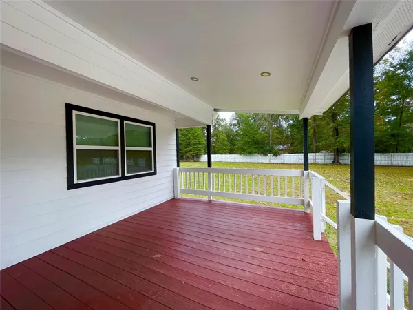 a view of empty room with wooden floor and ceiling fan