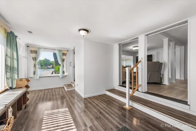 a view of a room with wooden floor and windows