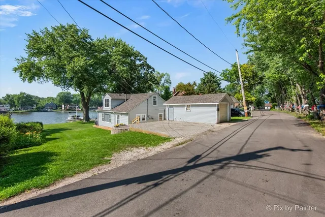 a view of a house with a yard and potted plants