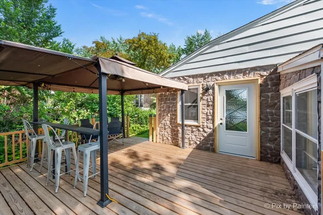 a view of a patio with table and chairs under an umbrella with wooden floor