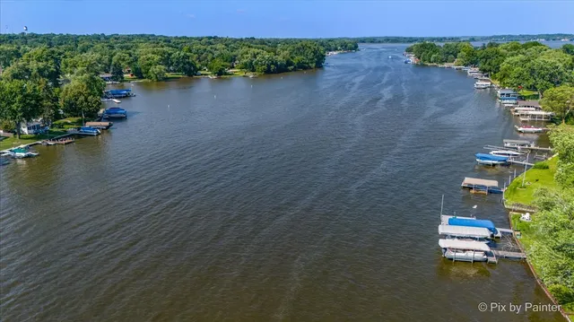 an aerial view of a house with a yard and lake view
