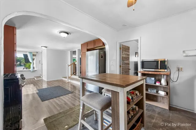 a living room with stainless steel appliances kitchen island granite countertop furniture and a flat screen tv