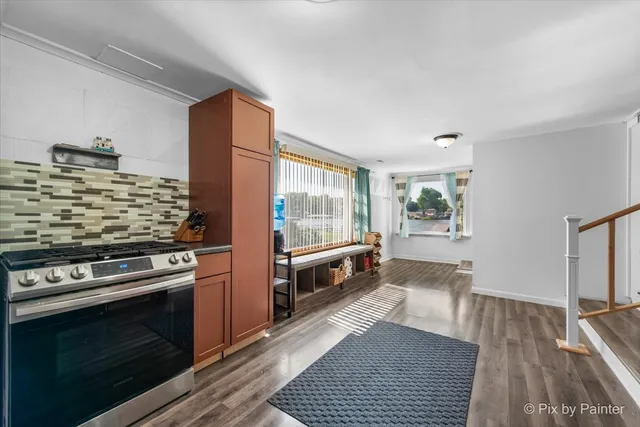 a kitchen with stainless steel appliances and wooden floor