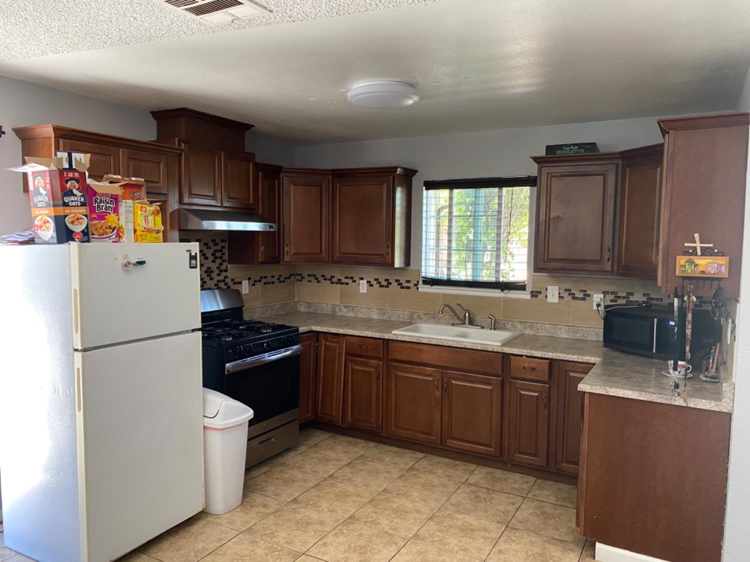 1978 Cline Street Firebaugh, CA 93622 - Photo 2 of 9 a kitchen with a sink appliances and cabinets