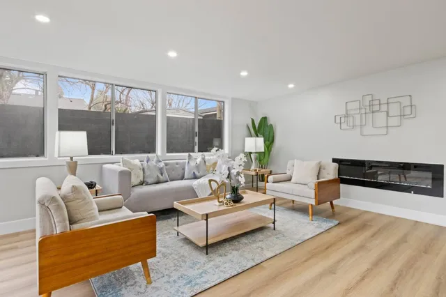 a view of a dining room with furniture a kitchen and wooden floor
