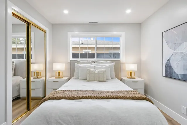 a bedroom with a bed and painting on the wall