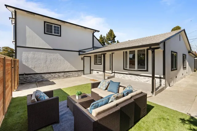 a living room with furniture a rug and a large window
