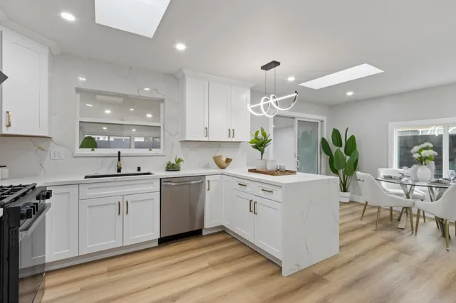 a kitchen with white cabinets and black appliances