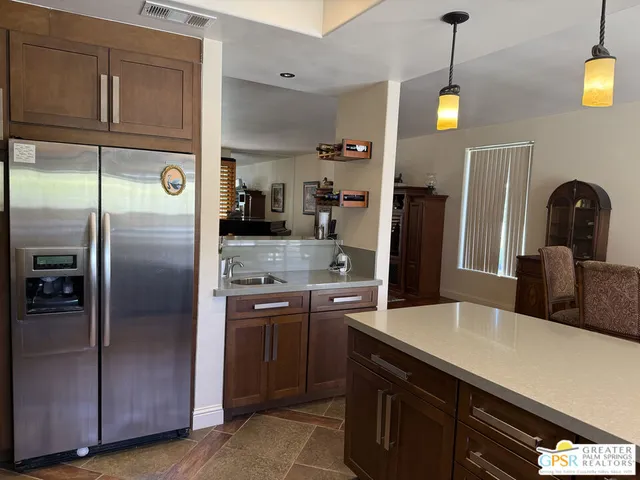 a kitchen with stainless steel appliances granite countertop a refrigerator and a sink