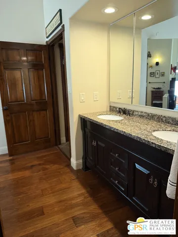 a bathroom with a granite countertop sink a mirror and shower