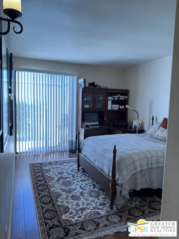 a bedroom with bed and wooden floor