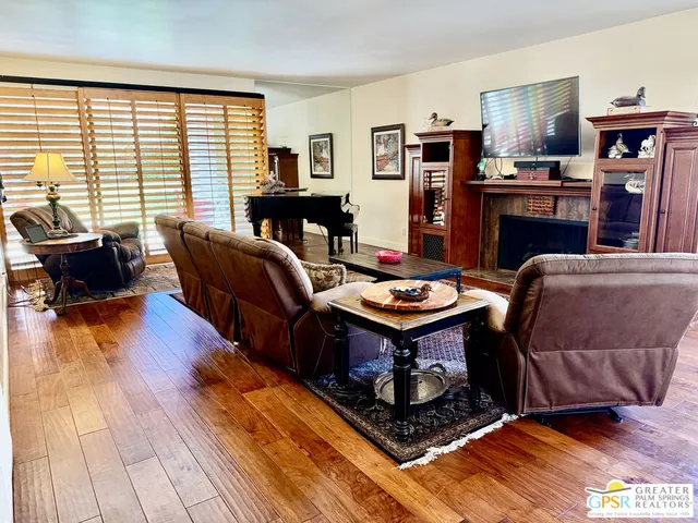 a living room with fireplace furniture and a wooden floor
