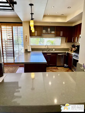 a living room with stainless steel appliances kitchen island granite countertop a stove and a sink