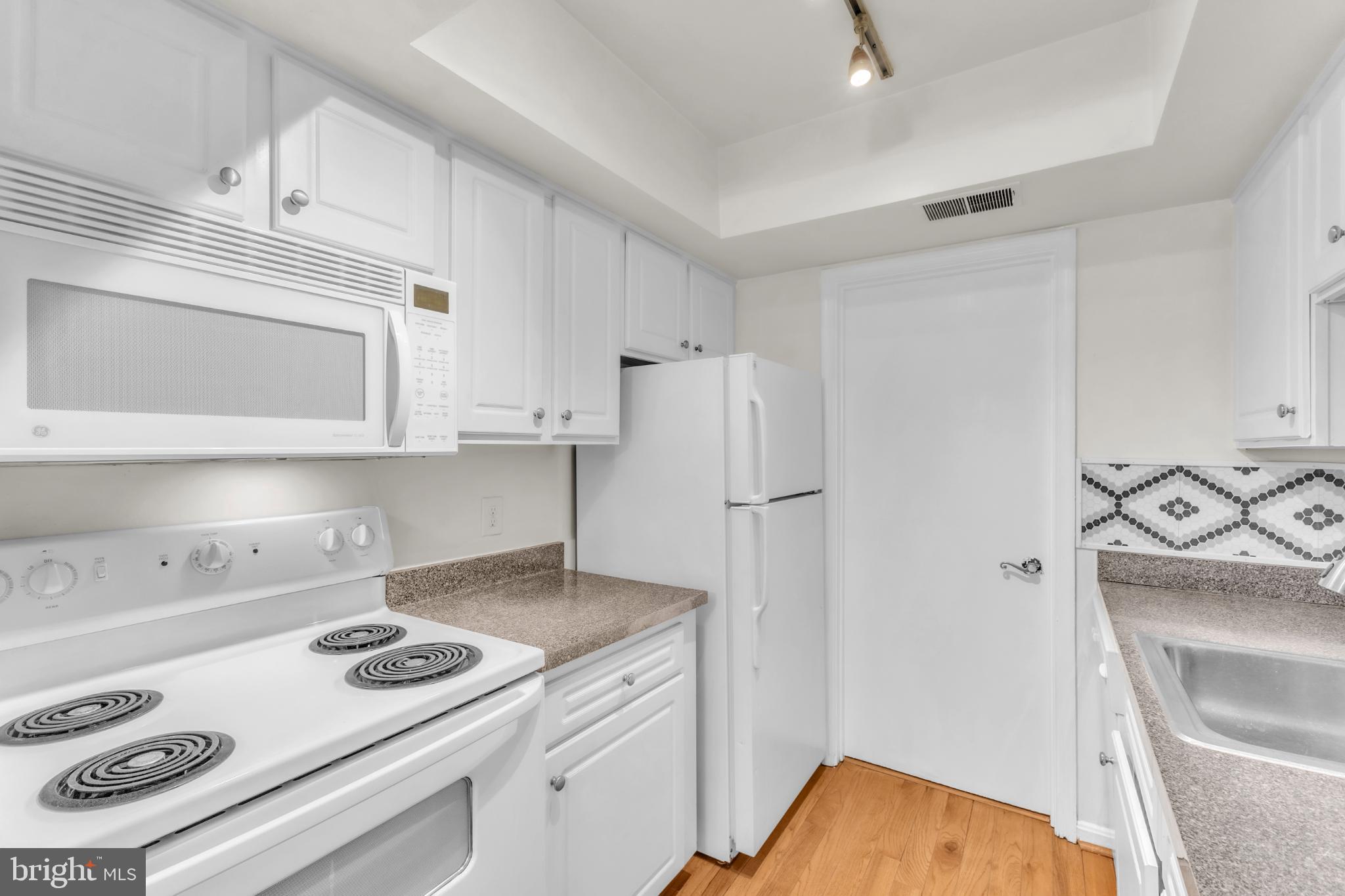 18334 Streamside Drive, Unit 201 Gaithersburg, MD 20879 - Photo 17 of 22 a kitchen with a stove and a refrigerator