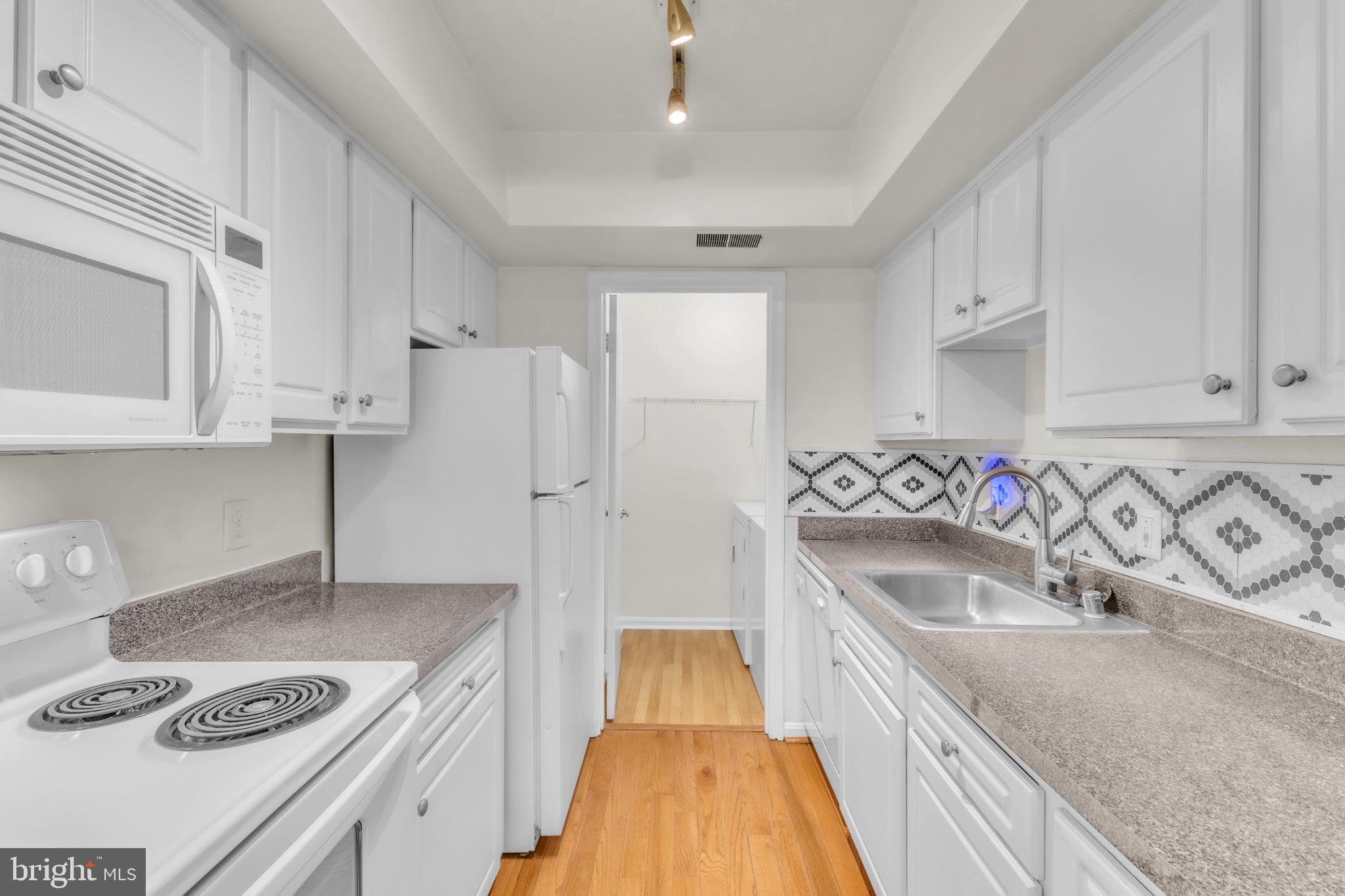 18334 Streamside Drive, Unit 201 Gaithersburg, MD 20879 - Photo 20 of 22 a kitchen with stainless steel appliances granite countertop a sink stove and refrigerator