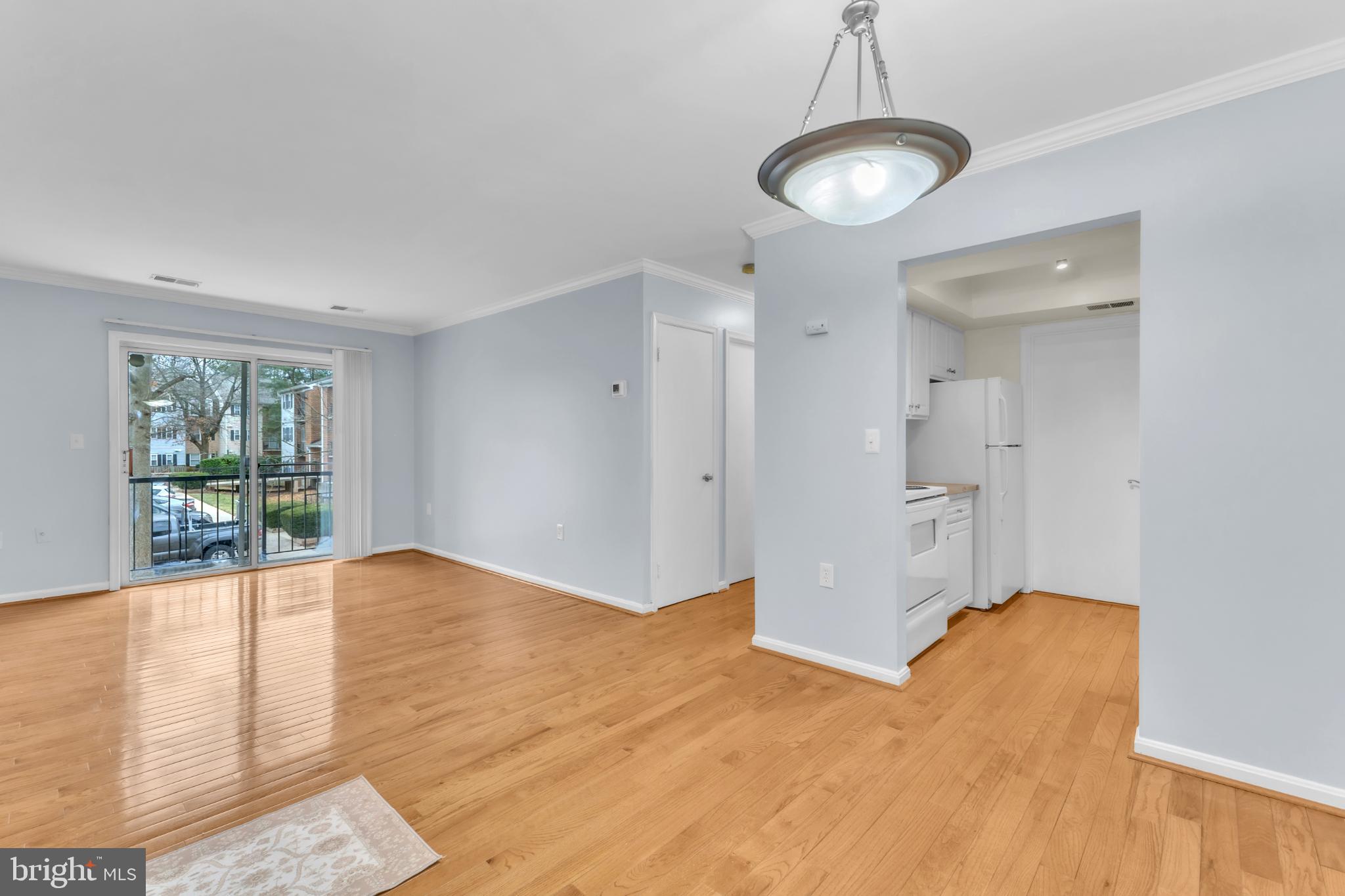 18334 Streamside Drive, Unit 201 Gaithersburg, MD 20879 - Photo 3 of 22 a view of empty room with wooden floor and fan