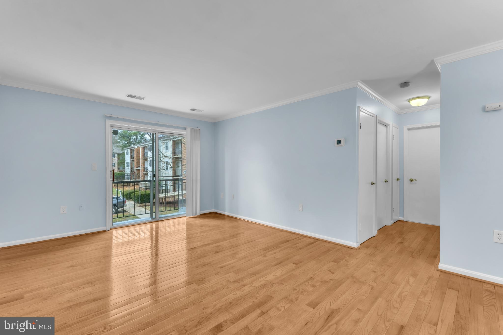 18334 Streamside Drive, Unit 201 Gaithersburg, MD 20879 - Photo 9 of 22 a view of an empty room with wooden floor and a window