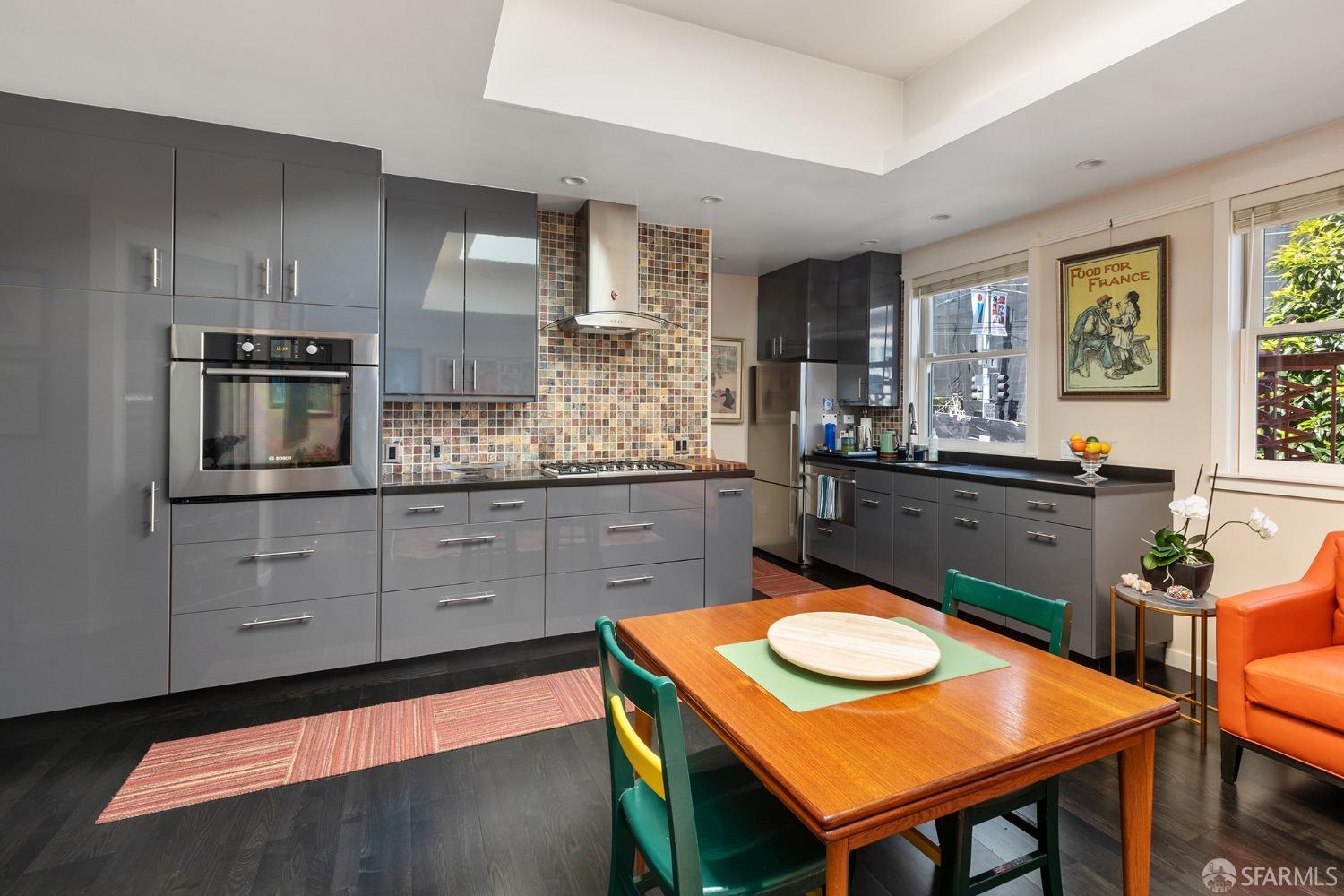 67-71 Haight Street San Francisco, CA 94102 - Photo 10 of 25 a kitchen with kitchen island granite countertop a sink a stove and chairs