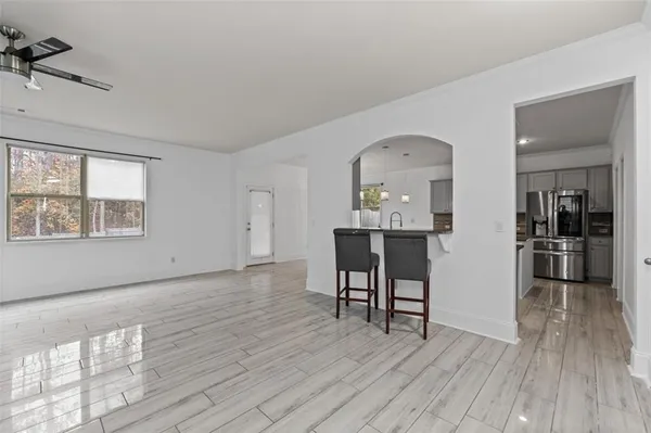 a view of a room with wooden floor windows and kitchen view