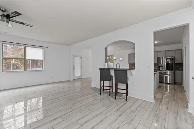 a view of a room with wooden floor windows and kitchen view