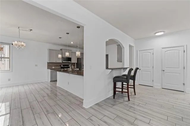 a kitchen with stainless steel appliances kitchen island hardwood floor sink and stove