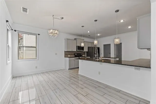 a large kitchen with stainless steel appliances granite countertop a large counter top and a stove