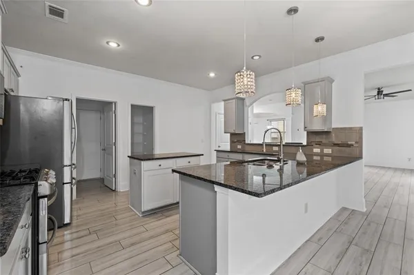 a kitchen with stainless steel appliances granite countertop a sink stove and refrigerator