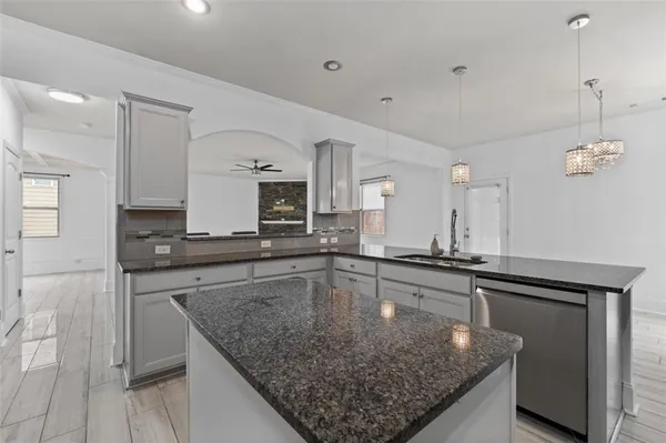 a kitchen with stainless steel appliances granite countertop a sink dishwasher and refrigerator