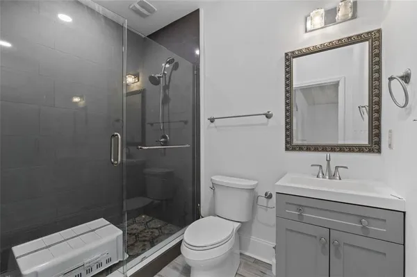 a bathroom with a toilet a sink a mirror and vanity