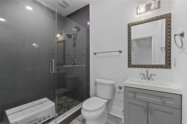 a bathroom with a toilet a sink a mirror and vanity
