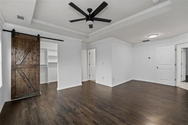 an empty room with wooden floor and a ceiling fan