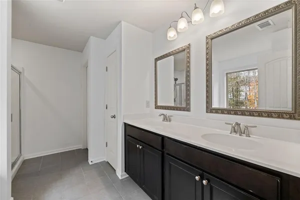 a bathroom with a double vanity sink a mirror and a shower