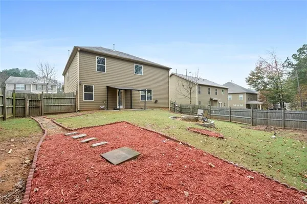 a view of a house with backyard and sitting area
