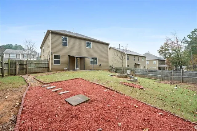 a view of a house with backyard and sitting area