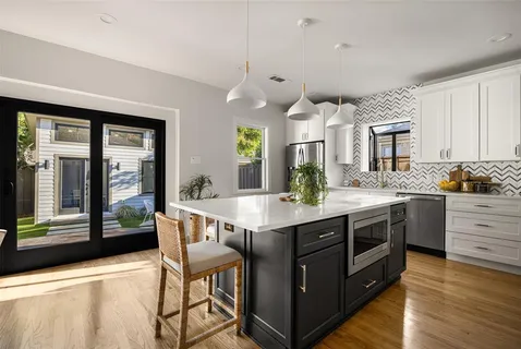 a kitchen with a stove kitchen island and living room