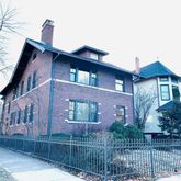 a front view of a house with glass windows and a tree
