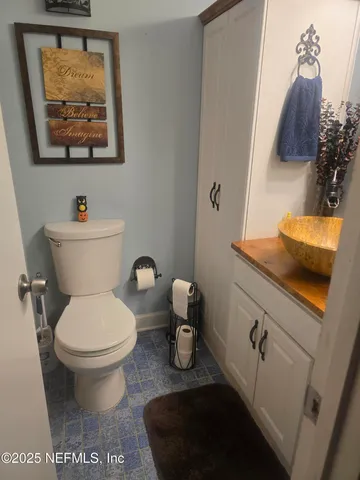 a bathroom with a toilet a sink and mirror