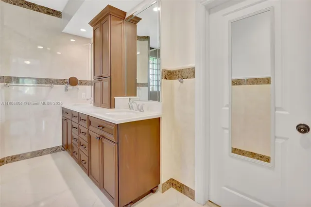a bathroom with a double vanity sink a mirror and a shower